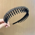 Close-up of black non-slip headband with sparkling grey rhinestones on a wooden backdrop - Black