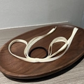 Détail de l'élastique à cheveux avec ruban beige sur plateau bois pour coiffure élégante - Blanc Cassé