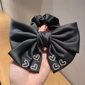 Elegante coletero de satén negro con lazo grande y brillantes de imitación en forma de corazón - Negro
