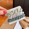 Détail de trois chouchous en tissu vert et crème fixés sur un support cartonné - Vert Pâle + Blanc Cassé + Vert à Pois / Combo Vert