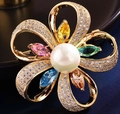 Dettaglio di una spilla a fiore con zirconi colorati, strass micro-incastonati e perla - Colore Oro Zirconia Multicolore