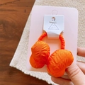 Detail of orange padded bow hair tie with textured fabric on a display card - Hair Tie / Orange