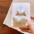 Detail view of cream quilted fabric bow hair tie with elastic band on display card - Hair Tie / Beige