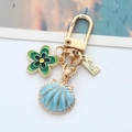 Llavero de aleación dorada con concha azul y flor verde para bolsos y llaves de coche - Concha Azul