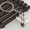 Close-up of a silver fighter jet metal keychain on a dark wooden background - Large Transport Plane (飞机16)