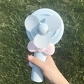 Lollipop style blue hand-press mini fan with pink bow detail and three-blade design - Light Blue