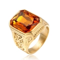 Dettaglio dell'anello in titanio dorato con gemma arancione rettangolare e motivi a rilievo - Oro Zircone Giallo