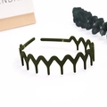 Close-up of a matte dark green wavy headband with anti-slip teeth on a clean white base - Wave Wide Tooth / Olive Green