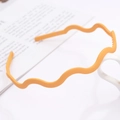 Close-up of a matte yellow wavy headband with anti-slip teeth on a clean background - Horizontal Wave / Goose Yellow