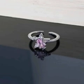 Close-up of star zircon ring with pink marquise gemstone on a reflective black surface - Style 5 Star Crossover Ring