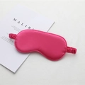 Hot pink silk sleep eye mask with elastic headband displayed on a minimalist book - Rose Red