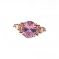 Rose gold ring with a large oval pink gemstone and small accent stones on the band - Ring