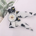 Close-up of daisy print fabric ribbon watch strap with polished silver case - Silver Case White Dial
