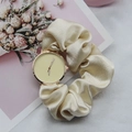 Champagne silk scrunchie watch strap with golden case against elegant floral background - Off White