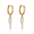 Close-up of golden hoop earrings with white enamel chili-shaped pendant on white background - White