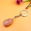 Detalle de piedra de cristal rosa envuelta en hilo de plata en un llavero de metal - Cuarzo rosa