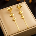 Goldene Herzohrringe mit langen Kettengliedern auf einer Schmuckschatulle - Gold Herz Quaste Stil (E5104)