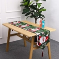 Détail d'un chemin de table de Noël avec motifs Père Noël et pompons rouges - Style A Père Noël