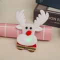 Detail of a glowing plush reindeer Christmas brooch with a red nose and striped scarf - Glowing Reindeer Style
