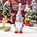 Gros plan d'un gnome de Noël avec un bonnet gris, barbe blanche et pompons colorés - Gris