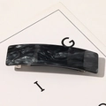 Détail macro de la pince à cheveux en acétate marbré avec mécanisme à ressort en métal - Gris Foncé Sable