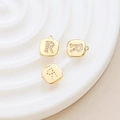 Macro shot of gold-plated square pendant with zircon letter R for DIY jewelry making - Letter R