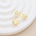 Detailed view of a gold-plated square pendant with sparkling zircon letter Q on a white stand - Letter Q