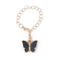 Detail einer goldenen Kette mit schwarzem Schmetterlingsanhänger und weißen Glitzersteinen - Schwarz