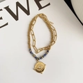 Dettaglio macro del bracciale a due strati in acciaio al titanio con malocchio e pietre blu - Stile Pietra Naturale Blu Malocchio