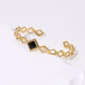 Minimalistisches geometrisches Titanstahl Armband in Gold mit schwarzem Rauten-Element - Offener geometrischer Armreif / Gold mit Schwarz
