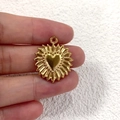 Nahaufnahme eines vergoldeten Edelstahl Herzanhängers mit Sonnenstrahl-Design-Details - 1 Herzförmige Sonne
