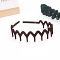 Detailed view of dark brown wave-shaped hairband with matte finish and non-slip teeth - Wave Wide Tooth / Dark Coffee