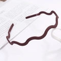 Matte dark brown wavy headband with anti-slip teeth in a minimalist lifestyle setting - Horizontal Wave / Dust Rose