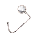 Macro detail of silver metal table hook featuring a clear faceted crystal decorative top - White