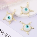 Close-up of golden starfish evil eye pendants on a purple surface with pearl accents - Starfish Eye