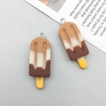 Dettaglio macro di ciondoli gelato in resina con strati sfumati cioccolato e vaniglia - Marrone