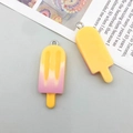 Macro shot of colorful resin ice cream pendants with metal rings for DIY jewelry making - Orange