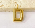 Macro shot of a chunky gold metal bubble pendant in letter D shape on stone surface - Letter-D / Steel