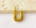Detailed view of a golden bubble letter U pendant with textured finish on stone - Letter-U / Steel