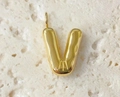 Close-up of a polished golden bubble letter V pendant on a textured stone surface - Letter-V / Steel