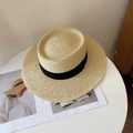 Nahaufnahme eines flachen Strohhuts mit schwarzem Band auf einem weißen Tisch - M (56-58cm) / Beige Fedora-Schwarzes Band