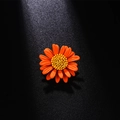 Vibrant orange daisy enamel brooch with a yellow center on a dark background - Orange