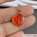 Close-up of a 17.8mm gold round Saint Benedict pendant with red enamel inlay details - Red