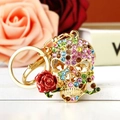 Macro di portachiavi a teschio con strass colorati e una rosa rossa tra i denti dorati - Stile Pietra Colorata