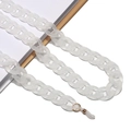 Detailed view of matte white acrylic glasses chain with gold links on minimalist background - White