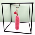 Detail of pink faux fur keychain with gold chain and small tassel on a metal stand - Rose Red