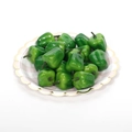 Miniature green bell pepper models displayed on a decorative striped paper plate - Mini Green Bell Pepper