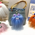 Blue fuzzy monster keychain with large eyes and metal clip hanging on a denim bag - Single Piece / Sky Blue