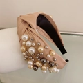 Detailed texture of fabric knot headband with champagne pearls and metallic beads - Champagne