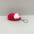 Detail of cute pink plush cat in a red hand-knitted sleeping bag keychain with silver ring - Rose Red